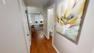 Hallway with wood finished floors and a textured 