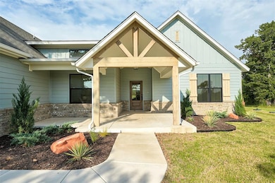 Front of the home with spacious covered porch and beautiful landscaping.