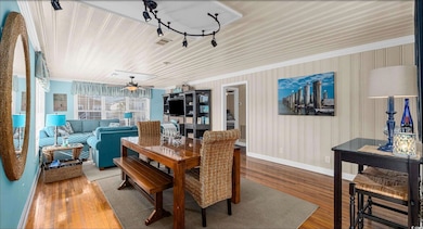 Dining room with wood finished floors, a ceiling fan, and ornamental molding