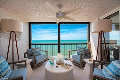 Sunroom with floor to ceiling windows, a water view, and a textured ceiling