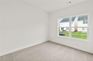 Carpeted empty room featuring baseboards and visib