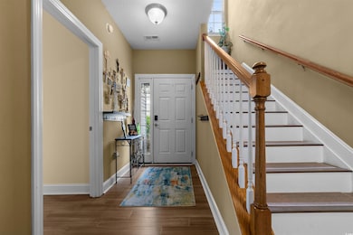 Entryway with wood finished floors, baseboards, an