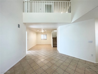 Unfurnished room featuring stairway, light tile patterned floors, and a high ceiling