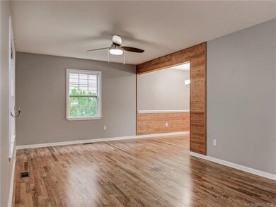 Living area with refinished hardwood floors.