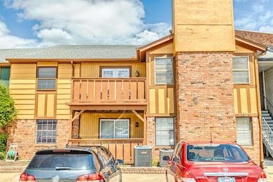 Townhome / multi-family property featuring a balcony, central AC, brick siding, and roof with shingles