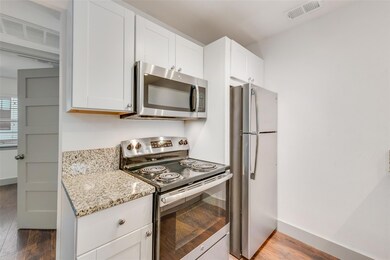 Kitchen featuring white cabinets, light wood-type 