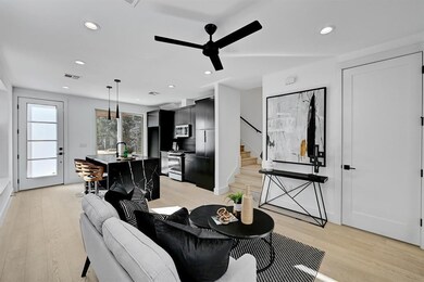 Living area featuring light wood finished floors, ceiling fan, stairway, and recessed lighting