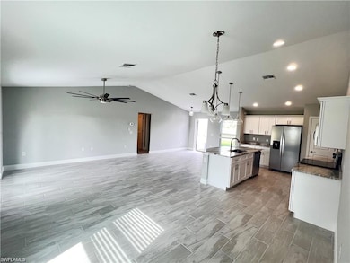 Kitchen with pendant lighting, lofted ceiling, a k