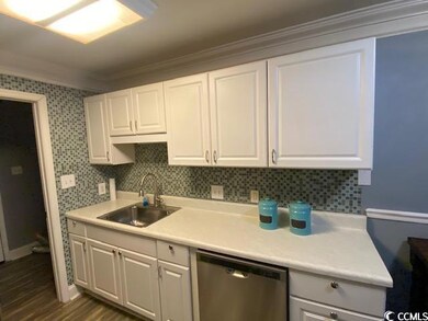 Kitchen featuring dishwasher, white cabinets, orna