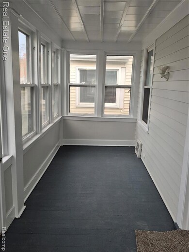 Unfurnished sunroom with beam ceiling and hardwood / wood-style flooring
