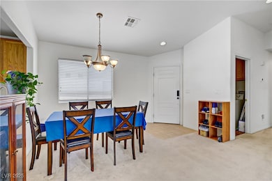 Dining space featuring a chandelier, light carpet,
