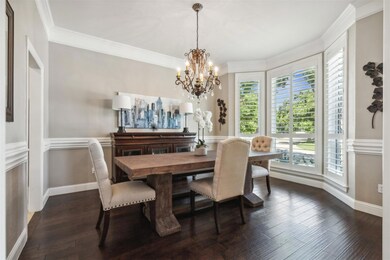 Dining room featuring dark wood-type flooring, a chandelier, and crown molding
