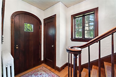 Inviting entry foyer with original woodwork and elegant staircase.