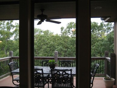View of the covered deck overlooking treed green s