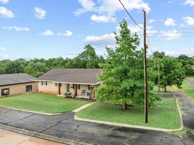 Single story home with a porch, a front yard, roof with shingles, and brick siding