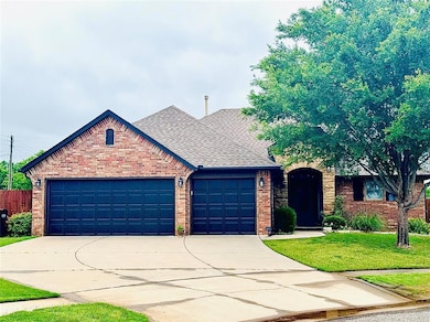 View of front of home featuring brick siding, an attached garage, driveway, and roof with shingles