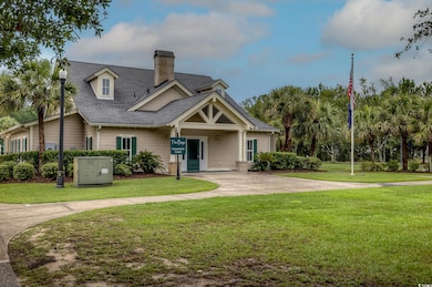 View of front of property with roof with shingles, a chimney, and a front lawn