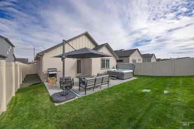 Rear view of property with board and batten siding, a fenced backyard, an outdoor hangout area, and a patio area