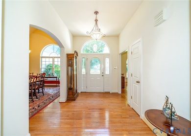Entryway with arched walkways and light wood finished floors
