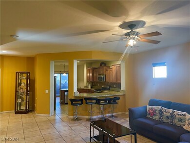 Living area featuring a ceiling fan, baseboards, a