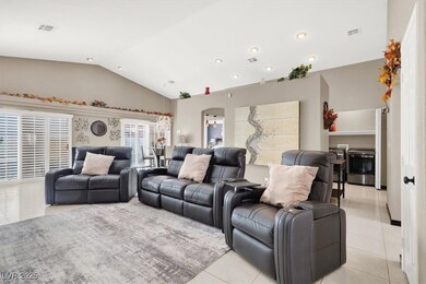 Living room featuring vaulted ceiling, light tile