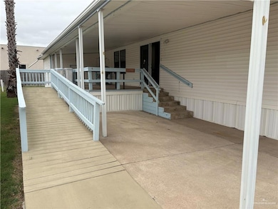 Property entrance featuring a porch and a carport and ramp