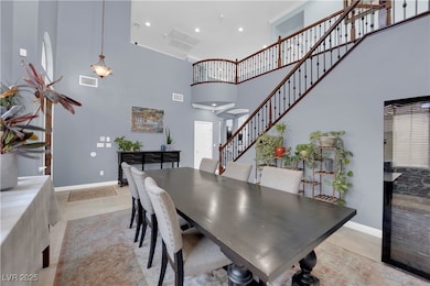 Dining area with a towering ceiling, light tile pa