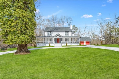 View of front of property with a porch, a chimney, concrete driveway, and a front yard