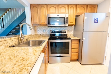 Kitchen featuring light stone counters, stainless