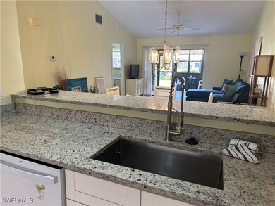 Kitchen with white cabinetry, hanging light fixtur