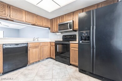 Kitchen with black appliances, light countertops,