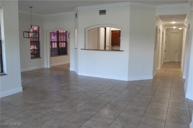 Empty room with crown molding, arched walkways, li