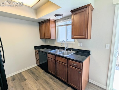 Kitchen featuring black dishwasher and light wood-style flooring
