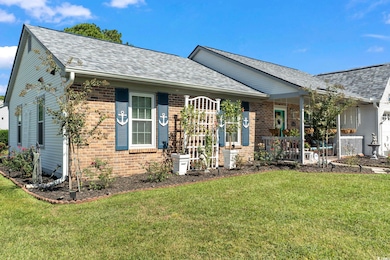 View of front of home with a front lawn, a shingled roof, and brick siding