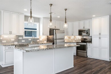 Kitchen features a large granite island and soft c