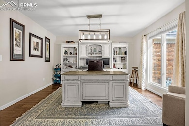 Office with dark wood-style floors and baseboards