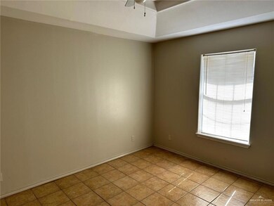 Empty room featuring light tile patterned floors and a ceiling fan