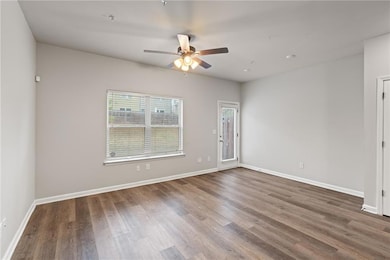 Unfurnished room featuring ceiling fan, wood finis