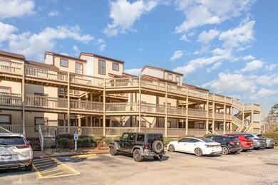 View of building exterior with uncovered parking
