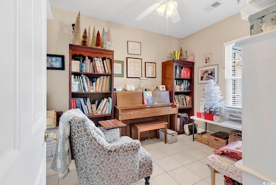 Home office with ceiling fan and light tile patter