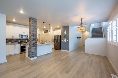 Kitchen with stainless steel appliances, connected to large family room.