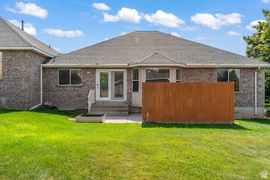 Rear view of house with brick siding, grow box, rear entrance and a secluded patio area