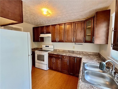 Kitchen with a sink, light wood-type flooring, gla