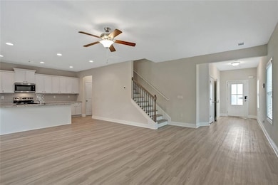 Unfurnished living room featuring ceiling fan and 