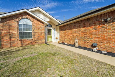 Entrance to property with brick siding and a yard