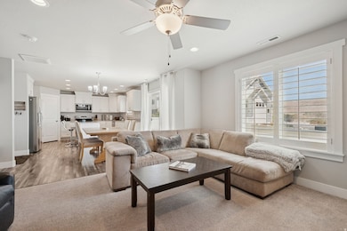 Living room featuring recessed lighting, a chandelier, ceiling fan, and light carpet