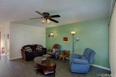Living room features tile flooring, smooth ceiling