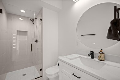Bathroom featuring a stall shower, vanity, and re