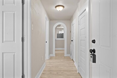 Hallway featuring light wood-type flooring, arche