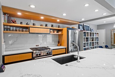 Kitchen with light stone counters, open shelves, 